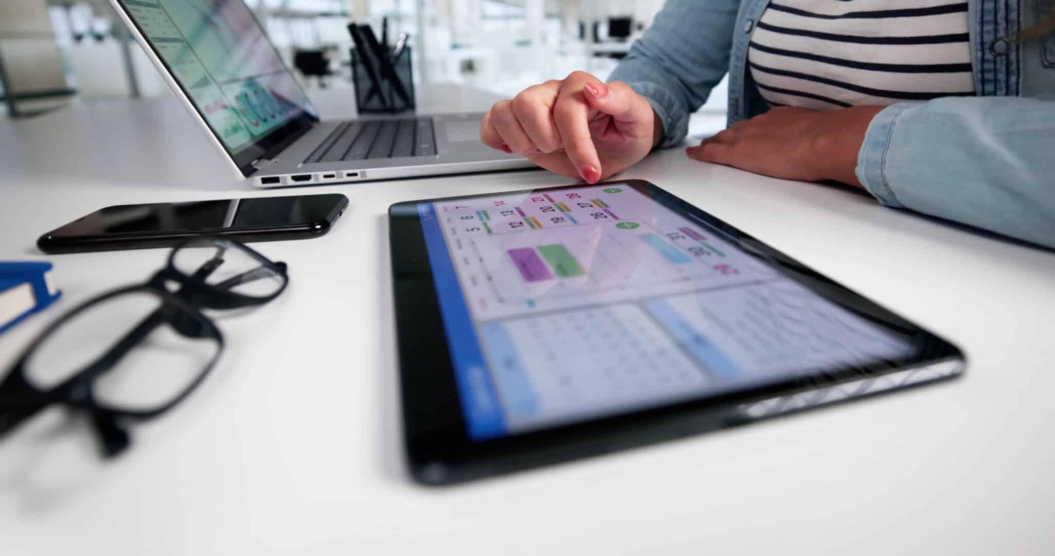 Software testing on a tablet with laptop and smartphone for quality assurance and app development.